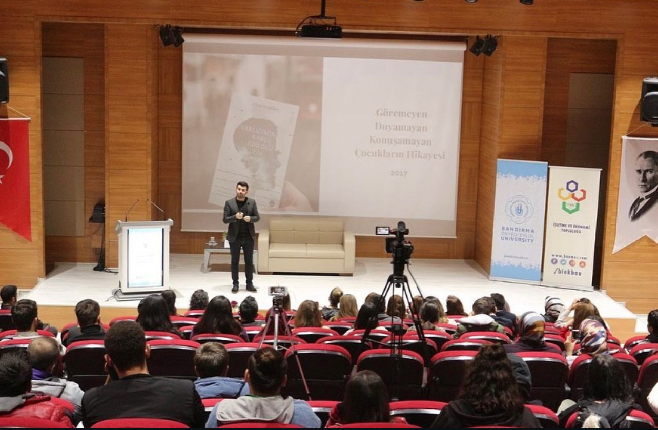 Cihan Buğdaycı bir üniversite konferansında konuşurken